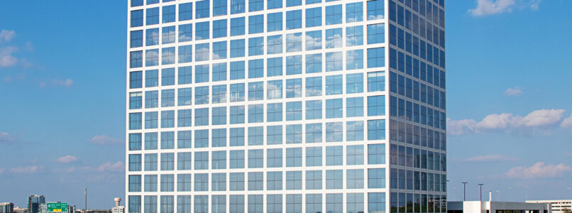 Glass office tower against a blue sky