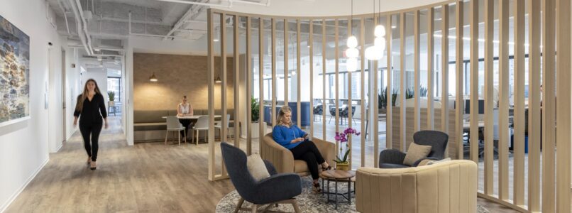 Lounge with armchairs inside a curved wood-slat screen in the Grant Thornton office