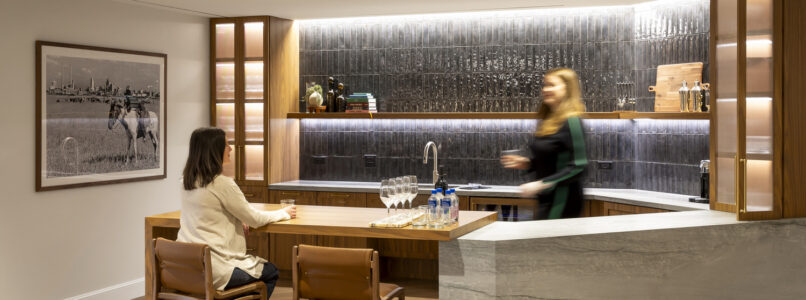 Two women at a marble kitchen island with wood bar stools in the Brunswick office