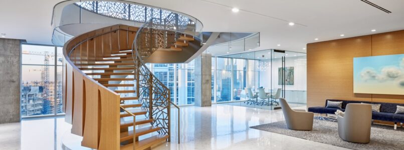 Spiral feature staircase rising from a lounge with city views in the Foley Gardere Dallas office
