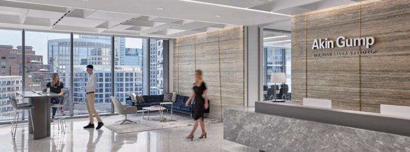 Akin Gump reception desk with stone front and wood logo wall