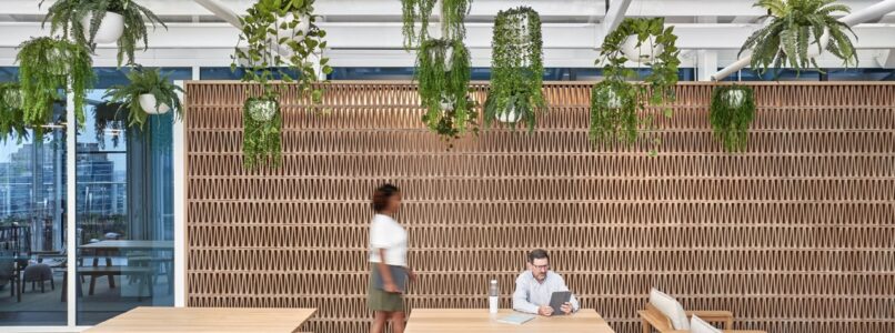 Covered terrace with wood tables, stools and hanging plants in the BCG Dallas office
