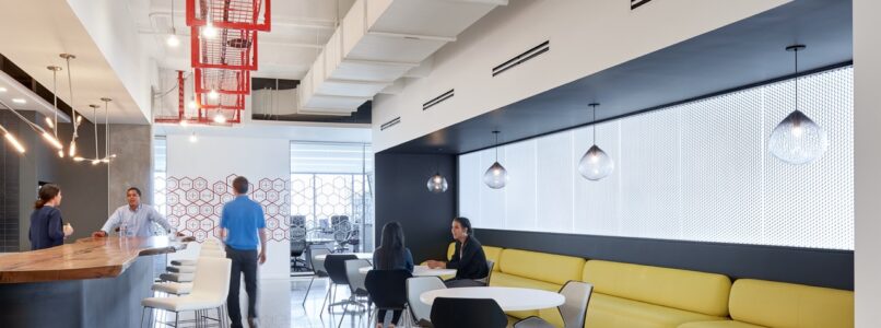 Break area with yellow banquette seating and red pendant light fixtures in the Hilti office