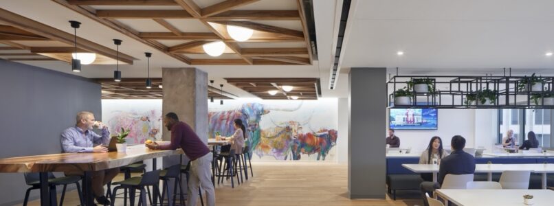 Cafe with a coffered wood ceiling, high-top tables and a colorful mural in the Thompson Coe Dallas office