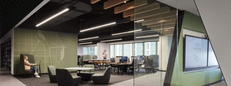 Open office with a wood-slat ceiling and angled glass meeting room in the Interstate Batteries office