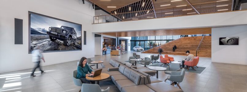 Lounge with gray seating and a large Mercedes-Benz photo wall at Mercedes-Benz Financial Services