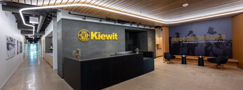 Kiewit reception desk under a wood-slat ceiling with curved lighting
