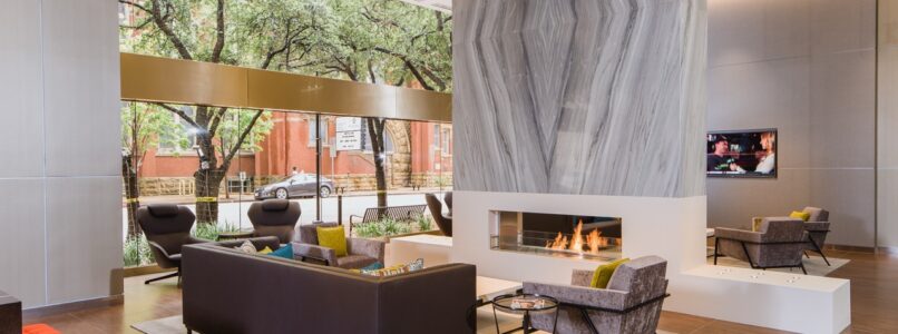 Lobby lounge with a marble-clad fireplace and contemporary seating at Ross Tower